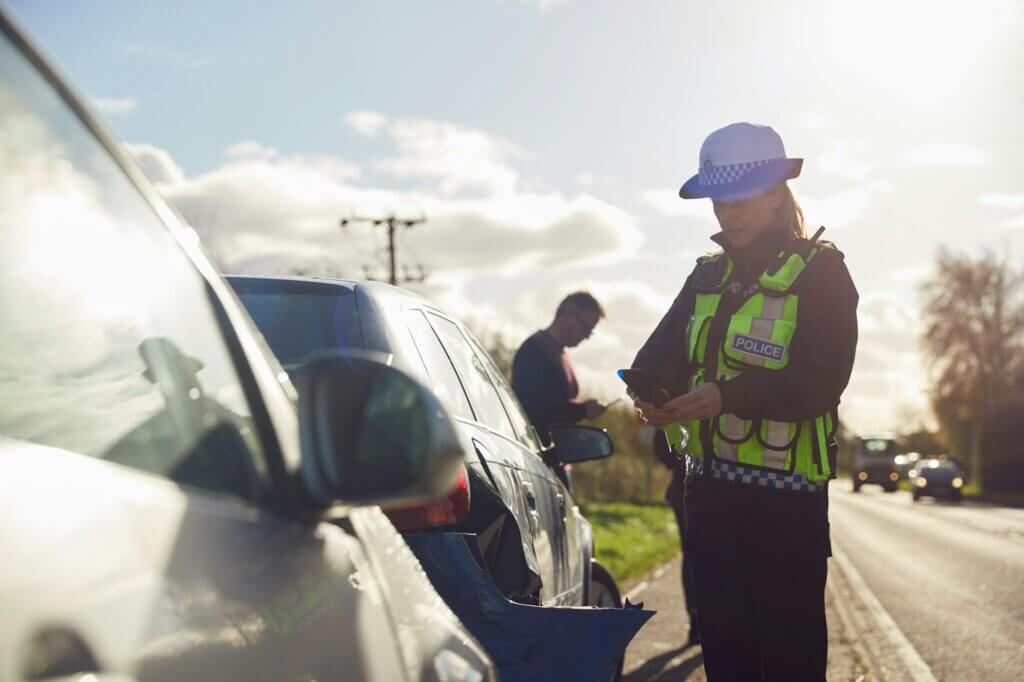 Female Traffic Police Officer Taking Photos On Mobile Phone At Road Traffic Accident